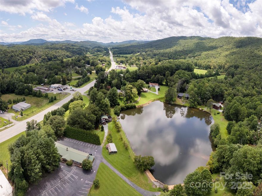 One of WNC's most unique properties w/ mixed uses possible. Event Center, a camp or a campus &  recreational. 5+ acre pond/lake w/event center, a house for VRBO/AirBnB or other uses. Event center has large spacious activity room, wardrobe/dressing rooms, service room, full kitchen for catering & public restrooms. Lower level offers possible expansion or other uses w/ open unfinished area & multiple locations pre-plumbed for bathrooms/kitchens and storage. House has multiple possible uses. Currently a short term rental but could serve as longer term rental, caretaker or offices (or combination). Lake belongs to property & is restricted to use by only the adjacent property owners & this property. No Motorized boats or water craft allowed. Old Barn also on property for storage. Beautiful setting with distant mountain views, lake front and lake views and sufficient parking for activities or events on property.  Must see to appreciate the property & to understand the mixed use options.