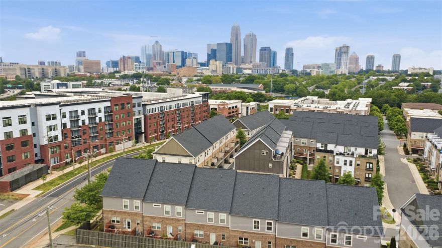 Experience elevated urban living in this stunning four-story modern townhome, ideally positioned in the heart of highly sought-after Plaza Midwood! Thoughtfully designed with both style and functionality in mind, this townhome offers effortless access to Uptown, NoDa, the Little Sugar Creek Greenway and some of Charlotte’s most vibrant dining and entertainment destinations. From the moment you enter, you’re welcomed by sleek engineered hardwood floors and a versatile lower-level suite complete with a full bedroom and bath, perfect for guests, a private home office or a quiet retreat. The main living level showcases an open-concept design tailored for both everyday living and entertaining, seamlessly connecting the living, dining and kitchen spaces. A designer-upgraded fireplace and accent wall anchor the living room, while the chef’s kitchen impresses with expansive cabinetry, a substantial island, stainless steel appliances and direct access to a private balcony. The third level hosts a serene primary suite designed as a true sanctuary, featuring a spacious walk-in closet and a spa-inspired en-suite with dual vanities, a stand-alone shower and a classic clawfoot soaking tub. A generously sized secondary bedroom with its own en-suite bath and a laundry room complete this floor, offering comfort and privacy for family or guests.
At the top, a flexible bonus space provides endless possibilities, ideal for a media room, fitness area or additional workspace, alongside a half bath and a spectacular rooftop terrace showcasing sweeping skyline views. With all appliances (including washer and dryer!) conveying and a prime location that blends convenience with vibrant city access, this exceptional home delivers the best of modern city living!