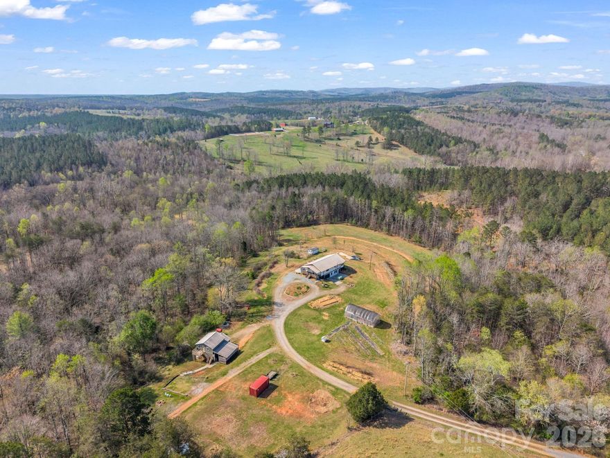 Welcome to Hidden Holler Farm. This working, homestead farm has everything in place and ready for its new owners to enjoy and continue their farming with all of the infrastructure in place. Private driveway leads to large modern farmhouse with an outstanding kitchen for the discerning cook ready to prepare and preserve their own farm to table experience. Eat in kitchen, large front porch and lower level patio for great flexibility to live and entertain. Primary bedroom/bath on main level, along with 2 more bedrooms, full bath and separate laundry. The lower level offers a large family room with outside entrance, 2 additional rooms that could be used as bedrooms or home office space, large storage area and a 2 car garage. Outside there are multiple fenced pastures with water and bordering a bold creek, with wooded areas for livestock shading or picnic tables next to the creek. Terraced orchard with apples, pears, blueberries and a variety of other fruits. Large 20' x 30' high tunnel greenhouse. Chicken coop and outdoor chicken run lined with fruiting shrubs to feed chickens. Underground farm workshop for processing and storing farm products. Several fenced pastures ready for farm animals or horses. The detached barn features a modern 1 bedroom upstairs apartment currently being used for short term rentals with private entrance and parking. Barn has workbenches, tractor storage and room for a variety of projects. There are even permits for the well and septic system for an additional house. Great farm to establish as a working/teaching farm retreat or just to enjoy your own private compound.