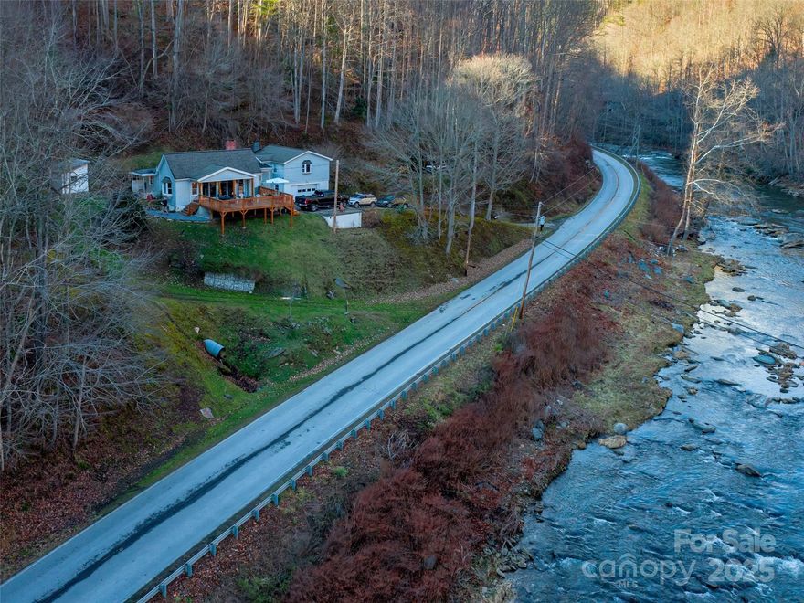 **MOTIVATED SELLERS** BRING OFFERS! NICE 2bd, plus office, 1 bath home, PLUS 62 ACRES, with newly built, large deck, gazing over THE CANE RIVER and LONG RANGE Blue Ridge mountain views! Sounds of the sprawling river are breathtaking! Land is filled with many species of trees, plants, and wildlife winding along the logging road! FISH, HUNT, SWIM, HIKE, or TRAIL RIDE on YOUR own property! Building spots and possible long range views in various places for PRIVATE cabins, tiny homes, or camping areas. The tastefully updated home is perfect for your Primary, 2nd home, or use as a short term rental. Enjoy the remodeled kitchen with newer appliances! Sit by the warm gas fireplace on cold winter nights! Spacious extra room for an office/nursery. Equipped with whole house dehumidifier and a spring filtration system with UV light. About 12 mi. to Burnsville Town Square and a short drive to The Appalachian Trail! The kitchen's 137sq ft is not counted because of ceiling height is just under 7ft at 80 inches, 6ft 6.6 inches.(Sq ft rules) The land is under Forestry Management lowering taxes! The home is not in a flood zone.