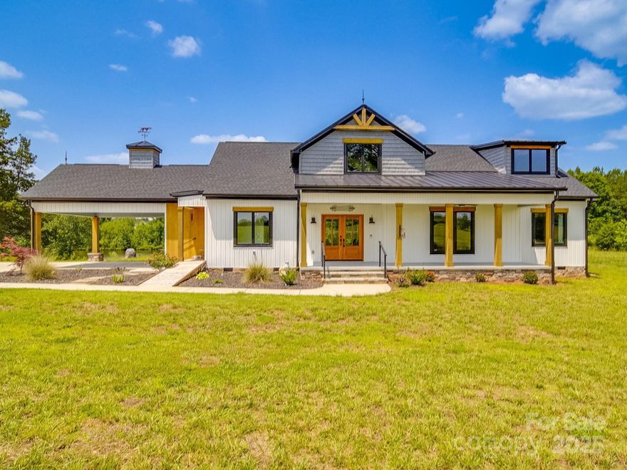 Nestled on over 9 acres of serene countryside, this exquisite modern farmhouse ranch offers the perfect blend of rustic charm & contemporary elegance. A spacious front porch sets the stage for relaxation & Southern hospitality. Step inside to an open split-bedroom floorplan, designed for both comfort & functionality. Natural light pours in through an abundance of windows, highlighting the seamless flow of indoor and outdoor living. The luxury kitchen stuns with an oversized island, perfect for entertaining, while overlooking the 2-story great room with soaring ceilings & cozy fireplace. Cornered barn doors open to a versatile billiards room, easily adaptable into a formal dining space, playroom, or home office. The primary suite offers a large walk-in closet & elegant ensuite with a soaking tub & seamless tile shower. Two additional bedrooms, with walk-in closets. Upstairs, showcases a bright & airy loft Enjoy the best of country living while remaining close to shopping and dining.