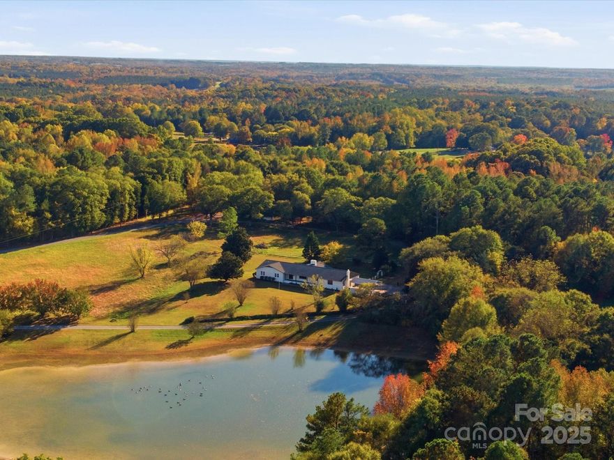 Embrace southern living at its finest in this beautifully updated brick ranch set on 8.4 acres with a shared, stocked pond. This spacious 4-bedroom, 2.5-bath home has undergone a full renovation, thoughtfully crafted for peaceful country living. Enjoy a cozy living room with a fireplace, an oversized great room with a wood-burning stove perfect for gatherings, and oversized bedrooms — including a primary suite with a custom zellige tile shower, boutique vanity, and hidden storage mirrors. The heart of this home is the custom kitchen, complete with highly sought-after Taj Mahal quartz countertops and custom cabinetry, paired with a meticulously designed walk-in pantry/laundry room hybrid. Prep for a Thanksgiving feast at the pantry island or enjoy a slow Sunday folding laundry — either way, you won’t want for space. Other luxuries include a sun-filled oversized sunroom, a rocking-chair front porch, and an expansive back deck, offering plenty of opportunities to relax and enjoy country living at its finest. Conveniently located just 5 minutes from I-77 yet tucked away for absolute privacy, this home blends comfort, space, and southern charm.