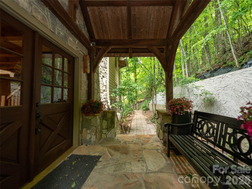 Stunning mountain retreat featuring stone and Hardie board siding with post-and-beam construction. Double front doors open to an open-concept layout with cathedral ceilings, hardwood floors, and abundant natural light. The living room centers around a cozy propane fireplace, while the sunroom offers incredible winter mountain views and private access from the primary suite. The kitchen and bathrooms feature slate flooring and granite countertops. The main-level primary suite fits a king bed, with a massive walk-in closet and a spa-like bath with soaking tub, walk-in shower, double vanity, and laundry chute. Upstairs includes a loft and two spacious bedrooms with large closets. The finished lower level, with chairlift access, is ideal for a guest suite, hobby room, or studio. A two-car garage offers space for a golf cart, plus a large storage room for outdoor gear. A perfect blend of luxury, comfort, and mountain charm.