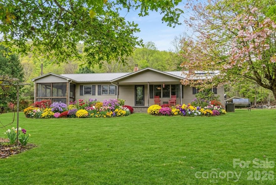 Discover your slice of mountain paradise in this charming one-level home nestled in the heart of the Celo Community within the picturesque South Toe Valley. This rare gem offers the perfect blend of comfortable living and endless outdoor possibilities that will make you wonder why you waited so long to escape to the mountains.

Step inside this thoughtfully designed three-bedroom, two-bathroom retreat where single-level living meets mountain charm. The home flows seamlessly from room to room, creating an inviting atmosphere that's perfect for both everyday comfort and entertaining guests who'll surely want to extend their stay. The screened-in porch becomes your favorite room in no time, offering the ideal spot to sip your morning coffee while listening to nature's soundtrack or unwind with an evening beverage as the mountain air works its magic.

But here's where this property truly shines – step outside and prepare to be amazed by the expansive flat parcel that's as rare as a unicorn in these mountainous parts. Gardening enthusiasts and aspiring farmers, this is your moment. The level terrain provides endless possibilities for cultivating your green thumb dreams, whether you're planning raised beds for heirloom tomatoes or envisioning rows of seasonal vegetables that would make any farmer's market vendor jealous.

The crown jewel of this property is undoubtedly Roaring Spout Creek, which gracefully borders the land. Imagine falling asleep each night to the gentle sounds of flowing water – nature's own white noise machine that never needs batteries. This natural water source isn't just pleasing to the ears; it's a gardener's dream come true, providing sustainable irrigation for all your agricultural adventures. No more worrying about drought conditions or sky-high water bills during growing season.

Location wise, you've struck gold in the South Toe Valley. The Celo Community is renowned for its tight-knit neighborhood feel where neighbors actually know each other's names and share garden surplus. This isn't just a place to live; it's a lifestyle choice that prioritizes community connection and environmental stewardship. The area attracts those who appreciate the finer things in life – clean air, star-filled skies, and the kind of peace that money typically can't buy.

With no restrictive covenants to cramp your style, you're free to let your creativity run wild. Want to add a workshop? Go for it. Dream of a greenhouse? Make it happen. Thinking about keeping a few chickens for fresh eggs? Got it. Perfect for anything your dreams desire.     Outdoor photos have been spring virtual staged.