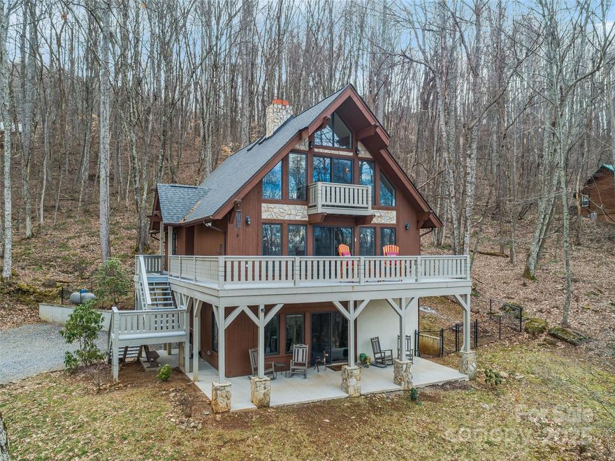 This is one of those special finds. Lovely mountain chalet perched on a hillside w/ year round long range views! Enjoy the serenity of the wooded subdiv. from any of the 3 levels of decks, while the convenience & entertainment of downtown Waynesville is only 5 mi away. Wood plank entry hall has built in bench & coat rack. Living room w/ gas fireplace, plank accent wall, beamed ceiling, & glass sliding door to deck/views.  Open dining room & kitchen. New Bosch fridge, stainless farmhouse sink, granite counters, undercabinet lighting, tile backsplash, pull out  softclose drawers & spice racks, & gas stove make this a dream kitchen. There is also a main level bedroom & bath with tub & walkin shower. The views get even better from the wall of windows in upstairs loft, as well as a large primary suite w/ private exterior balcony, ensuite w/ skylight, double vanities, glass/tile shower w/ double shower head. Lower family room w/ gas f/p & bath. Rest easy w/ LP generator for backup power.