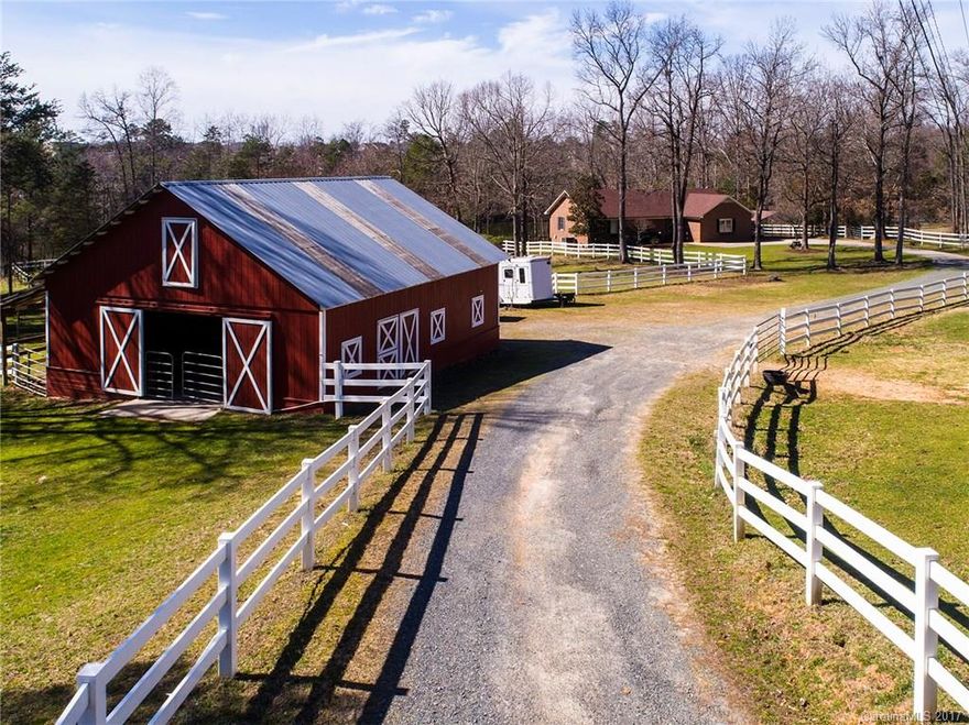 Rare opportunity in Fort Mill, just over the NC/SC line! Fabulous horse farm on 10.35 acres w/3 stall barn, tack room & hayloft; riding arena, fenced pasture, stocked pond, complete with a charming brick ranch w/lg. deck overlooking the pond! All major systems, roof & fencing replaced in recent years. Close to I 77, neighborhood schools, shopping etc. A private enclave tucked away from surrounding growth. Includes 2 add'tl parcels (#6510..72 & 6510..21) Peaceful & serene setting. Home Warranty.