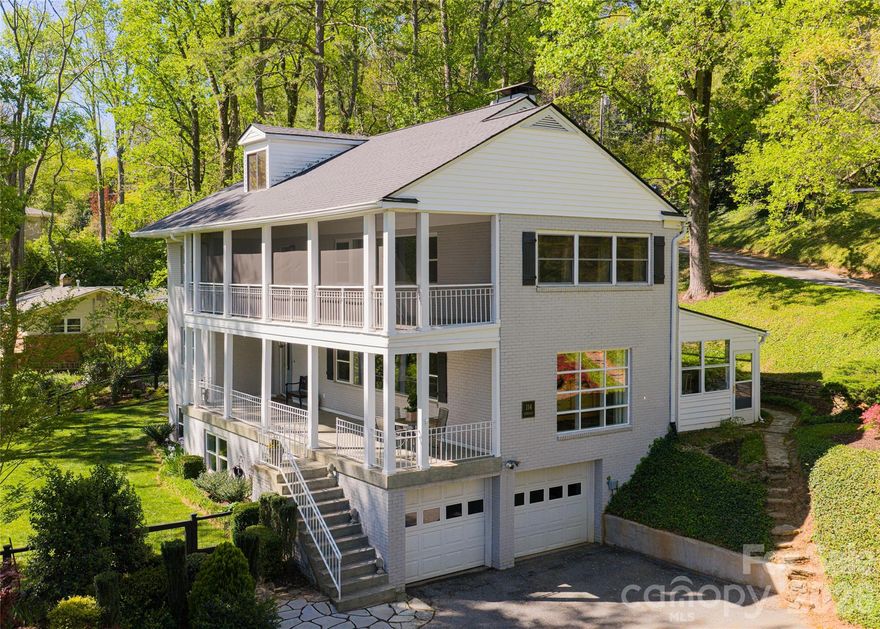Timeless design meets modern comfort in this charming North Asheville retreat, where natural light, mountain views, and thoughtful updates come together effortlessly. On a quiet street with no through traffic, this home offers the rare combination of privacy, convenience and character, just a short distance to Merrimon Avenue shops and restaurants, UNCA trails and Beaver Lake, and only two miles from downtown Asheville.  Inside, you’ll find four gracious bedrooms and sun-filled living spaces highlighted by oversized windows and a warm, inviting gas fireplace. The home’s unique Charleston-style double-decker porches add immense charm, including an upper-level screened porch that captures beautiful morning light, ideal for coffee or quiet relaxation. The property’s established landscaping features stone walls and winding paths, opening to a wonderful flat yard ideal for entertaining, play or pets. Two additional side porches offer endless possibilities for outdoor living and creative use. Modern updates provide peace of mind, including a new roof and gutters (2025) and new interior doors, while a versatile bonus room with a full bath adds flexibility for guests, work or recreation. Abundant storage is a standout feature, with over 700 square feet of attic space. A two-car garage and ample additional parking ensure space for everyone. This is a special home, where subtle refinement meets nature and everyday convenience in one of Asheville’s desirable neighborhoods.