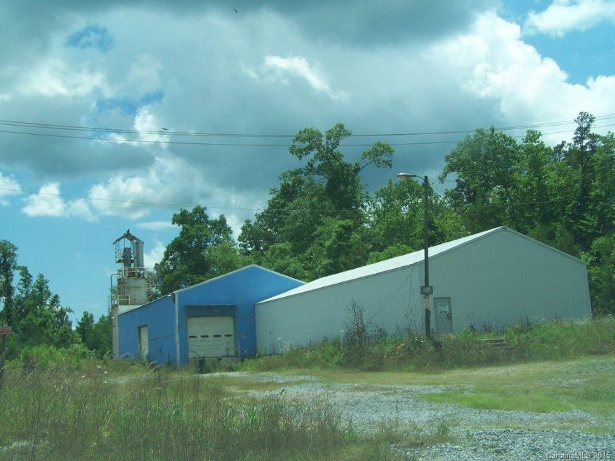 Access to the property is via Dickson Rd. from Kings Creek. Lots of frontage on Highway 97. The location has good access to I-85 from Highway 5. Building has 14/20' eaves, unfinished interior. There is no current plat. Land value will be per acre. There is neither a well nor a septic tank. The price of the property has taken this into consideration. The 2 large buildings have lots of potential uses - light industrial, warehouse, repair shop, etc. No zoning; private location.
