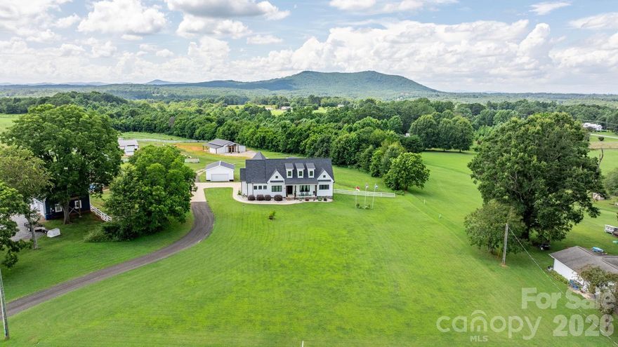 Dreaming of building your own modern farmhouse with acreage, mountain views and endless possibilities?  Look no further, someone else has done the designing and building for you!  Better than new, this custom-built stunning modern farmhouse was built in 2020 and sits on nearly 19 acres of peaceful countryside with a natural spring and a walking trail on the property ready for you to explore.  Ten of these acres are already fenced in so bring your animals.  This property offers the privacy, space, and serenity of rural living while still being just minutes from town. It’s the rare property that gives you the best of both worlds: a true country setting with easy access to Hickory’s shopping, dining, schools, and conveniences.

The home’s warm, modern aesthetic is elevated even further with a rocking chair front porch and stunning iron front doors that make a bold, welcoming statement.  Once inside, this thoughtfully designed home blends clean modern design with classic farmhouse warmth. Sun-filled living spaces, quality craftsmanship, and an inviting open layout make it ideal for both everyday comfort and effortless entertaining.  

Many upgrades in this design, including marble countertops in kitchen and baths, state of the art "smart" appliances, custom cabinetry, hand scraped wood floors throughout, 10 ft. ceilings and 8 ft. doors.  The kitchen is a chef's dream, and you will love the extra thought and expense given to creating a space you will enjoy cooking & entertaining in for years to come. As a bonus to this beautiful kitchen, there is a large cafe style window that opens up to your spacious covered back porch. This space will be one of your favorite spots for morning coffee, relaxing with family and friends, taking in the views and watching those gorgeous sunsets.  The inviting family room is comfortable, spacious and features built-ins, fireplace and is open to the formal dining area with plenty of room for a large table to seat all of your guests Next, prepare to be wowed by the spacious primary bedroom features a gorgeous primary bath with tile floors, tile shower, double vanities with marble counters, "smart" mirrors, soaking tub and a walk-in closet sure to please the pickiest buyers! There are 3 additional bedrooms on the main level, one of those bedrooms is currently being utilized as a home office.  Another full bath and a powder room with beautiful finishes complete the baths on the first floor.  You also have main floor laundry/mudroom with storage and organization built in.  Every convenience is on one level, but this couple has thought of everything in this design and even included a bonus space upstairs that has a separate entrance.  This is currently set up as a 5th bedroom and it has its own kitchenette and full bath, perfect for guests, mother-n-law suite or even has the potential to be a rental opportunity!  For parking you have an attached oversized double garage and a separate 24x24 double garage/workshop.

Once outside and the land opens up around you—rolling acreage, room to explore, and endless possibilities for recreation, hobbies, or expansion.  A major highlight of the property is the brand-new barn completed in 2025. Designed with versatility in mind, it’s already set up to function as a venue—perfect for weddings, events, workshops, or gatherings. But its potential doesn’t stop there. Whether you envision an equestrian facility, a creative studio, a hobby barn, or an income-producing venture, this space is ready to bring your ideas to life. It has ample space, 3 half baths, a full kitchen and boasts 2,343 square feet.  

With its modern farmhouse charm, expansive acreage, barn/venue opportunity and unbeatable Hickory location, this property offers a rare & unique opportunity to create the lifestyle you’ve been dreaming of.  Book your showing today!