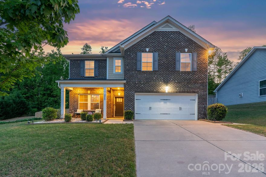 Beautiful brick-front 5-bedroom, 3-full bath home situated on a spacious lot in the desirable Heritage Hall community. Ideally located just minutes from Charlotte's Ballantyne area, offering convenient access to premier shopping, dining, entertainment, and major highways. The open-concept main level features a formal dining room with tray ceiling and crown molding, flowing into a well-appointed gourmet kitchen with a large center island, wall oven, walk-in pantry, and generous breakfast area. The kitchen opens seamlessly into a warm and inviting family room, highlighted by a cozy gas fireplace—ideal for both daily comfort and entertaining. A main-level guest suite adds flexibility and convenience, perfect for visitors or multi-generational needs. Step outside to the screened-in porch, where you can relax and enjoy views of the private, tree-lined, fenced backyard—offering plenty of space for recreation, gardening, or a peaceful retreat. Upstairs, the spacious primary suite showcases a tray ceiling, elegant crown molding, and an abundance of natural light. The en-suite bath includes a double vanity, soaking tub, tiled shower, and walk-in closet. Three additional, generously sized bedrooms, a full bath, laundry room, and a versatile loft area complete the second level. Energy-efficient solar panels add long-term value and savings.
