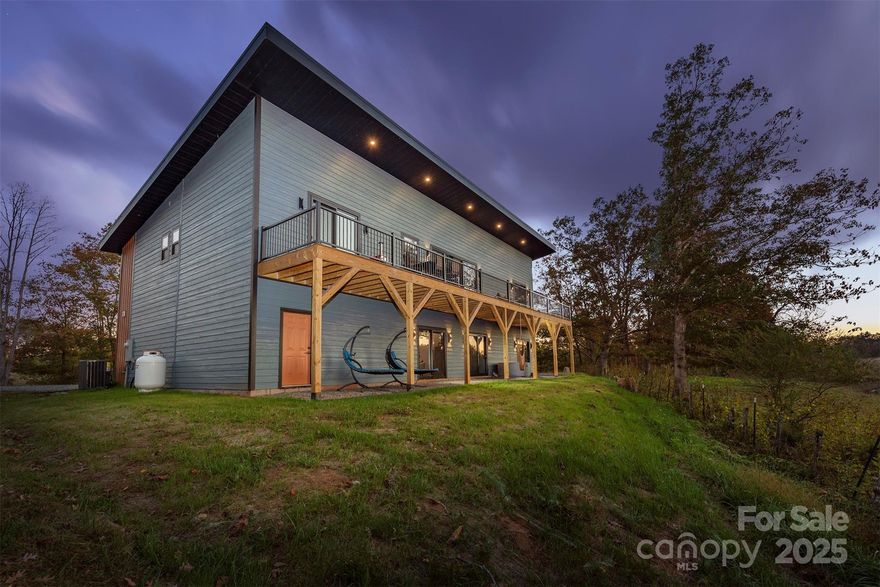 NEW CONSTRUCTION - MUST SEE! Just 10 mins to downtown Weaverville and 20 mins to Asheville, this modern country home is set on 1.96 acres with a pasture area, Open Use zoning, and an easy-access driveway. The upstairs features soaring 16' ceilings, an open-plan living-dining-chef’s kitchen with high-end appliances including a 48" dual fuel range with double ovens, grill/air fryer, pot filler, drawer microwave, whisper-quiet dishwasher, auto-open refrigerator, custom coffee station, and gorgeous quartz and soapstone countertops. Matching soapstone vanities are found throughout the home. A TREX deck extends the living space outdoors. On this level, you’ll find two ensuite bedrooms on one side of the home, while the large primary suite occupies the opposite wing with a spa-like bath featuring a huge walk-in, walk-out shower for two, soaking tub, and custom closets. The office, pantry, half bath, and laundry complete this floor. Walk down the custom oak staircase to the lower level, where you’ll find a two-car garage, gym, large 4th bedroom with a custom-designed bathroom, huge utility/storage room with dog washing station and second laundry, plus an expansive 30x18 flex area perfect for a game room or theatre. Step outside to the hot tub and take in the views. Additional highlights include all bathrooms with built-in Bluetooth speakers, oversized Pella impact windows and doors that frame the mountain ranges, designer lighting and fixtures, custom closets and laundry on both levels. This exceptional property offers both privacy and convenience. Your move-in-ready mountain retreat awaits!