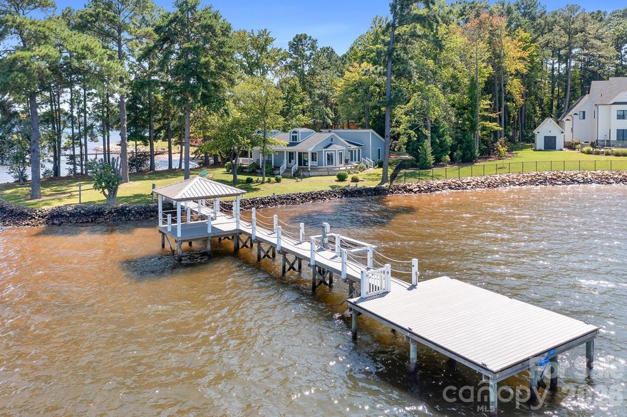 One of a kind, Big Water!, Long Range 5 mile view! Surrounded by Multi-Million Homes, this lot stands out!  Peninsula Lot, private beach area, numerous upgrades including a beautiful pier w/ personal watercraft lift and covered gazebo.  Now's the time to take advantage of huge savings for this Fantastic Waterfront Property!! Building Envelope is approx. 125' W x 90' D. Plenty of room to construct a big beautiful home.  You'll have one of the most breathtaking backyards on Lake Norman.   The views are simply breathtaking!  So many possibilities!..use the existing home for a weekend getaway, full time residence or build your dream Waterfront home!  One of the very best waterfront lots on the lake!  New Well Pump, piping etc installed in 2023, in process of converting to private well. 
By Appointment Only!...Come see this fabulous property for yourself! Please note that the property to the right sold for 2.2 M in 2024, they razed the existing structure and are building a huge beautiful home.  Home/property is connected to Public Sewer ( Lincoln County).
