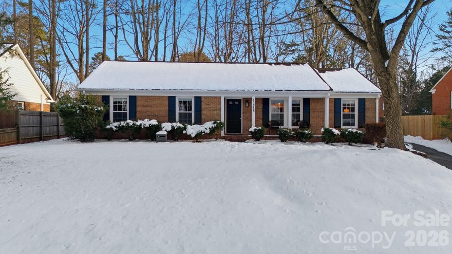 Classic full-brick ranch nestled on a quiet, elevated cul-de-sac street in the highly desirable Sardis Forest neighborhood, offering timeless curb appeal, a welcoming front porch, and a peaceful residential setting. Inside, the home features a bright, open layout with hardwood floors throughout, newer windows, vaulted ceilings, updated lighting, and a well-designed flow that is both functional and inviting. The foyer opens seamlessly to the main living spaces, including a spacious living room centered around a floor-to-ceiling masonry fireplace with new gas logs and direct access to the rear patio, creating a calm and comfortable atmosphere for everyday living. An open kitchen and dining area showcase timeless white cabinetry with soft-close drawers and cabinets, a smooth-top range, and ample workspace for everyday living and entertaining. Just off the main living area, a dedicated office or study with French doors provides an ideal work-from-home or flex space. The private primary suite is tucked at the rear of the home and features an updated ensuite bath. Two well-sized secondary bedrooms are located at the front of the home and share a full hall bath. Custom adjustable closet systems throughout are designed for flexibility and organization. All three bedrooms, as well as the study, include crown molding, adding a refined architectural touch. Outdoors, the fenced backyard is private and park-like, featuring a paver patio and fire pit, perfect for relaxing or gathering with friends. Solid brick construction, a single-story layout, and thoughtful updates throughout make this home move-in ready. Optional Sardis Forest Swim Club membership may be available. The home is ideally located near shopping, dining, parks, and walkable greenway access. Don’t miss this rare opportunity to own a classic ranch in one of South Charlotte’s most established neighborhoods.