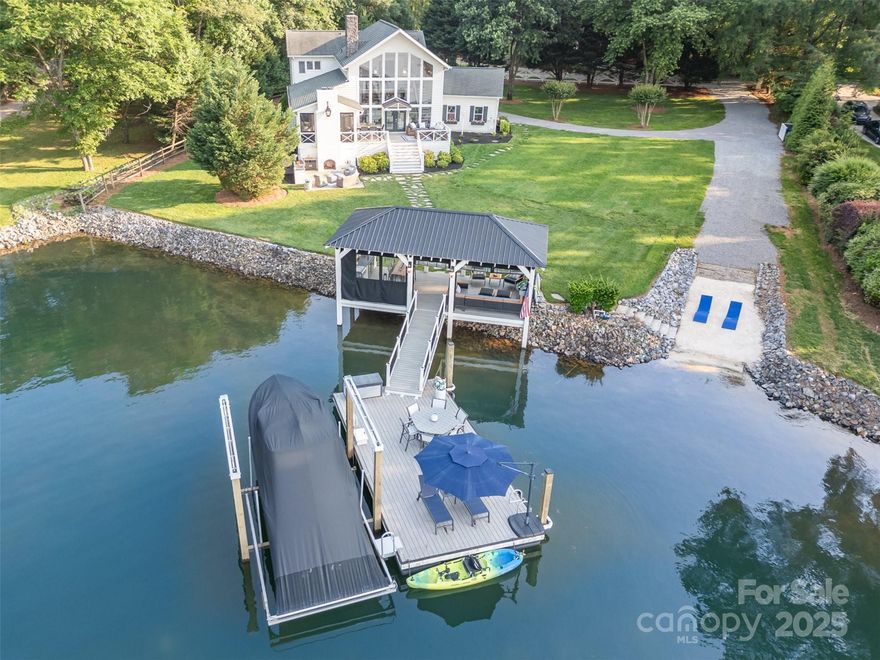 Experience the perfect blend of Southern charm and lakeside luxury in this stunning Low Country-Coastal Style home. Designed for those who appreciate indoor elegance and incredible outdoor living, this property offers breathtaking water views and an abundance of natural light from the soaring two-story great room. Nestled on a spacious, beautifully landscaped lot, this home is a haven for outdoor enthusiasts. Effortlessly entertain in the outdoor kitchen, unwind on the patio, screen porch, or deck, and soak in stunning lake views from the lake pavilion/dock. For boating lovers, you will appreciate the private dock/boat lift/boat ramp and beach area, the perfect setting for waterfront enjoyment. For those desiring main level living, the primary suite offers a full wet room and laundry. Located just beyond The Point with no HOA dues, this property presents a rare opportunity for personal enjoyment or investment potential as a lucrative vacation rental. The ultimate Lake Norman retreat!