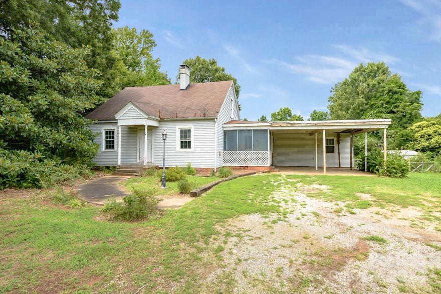 Welcome to 2508 Mooresville Road, a charming 1940s home, offering 4 bedrooms and 1 bath across 1,380 sqft. Situated on nearly 1.5 acres, this property is perfect for those looking for space and privacy. The home features an open floorplan, creating a seamless flow between the living, dining, and kitchen areas. The living area flows seamlessly into the dining space and kitchen, creating a warm and inviting atmosphere. The kitchen boasts plenty of counter space and cabinetry, perfect for whipping up your favorite meals. The finished attic offers extra space, perfect for a bedroom or office. Outside, enjoy the convenience of an attached carport and relax on the screened porch overlooking the expansive yard. While the home needs some work, it presents a fantastic opportunity to add your personal touch. Located less than an hour from Charlotte via I-85, this home offers both tranquility and accessibility. Don’t miss this chance to create your dream home in a beautiful setting!