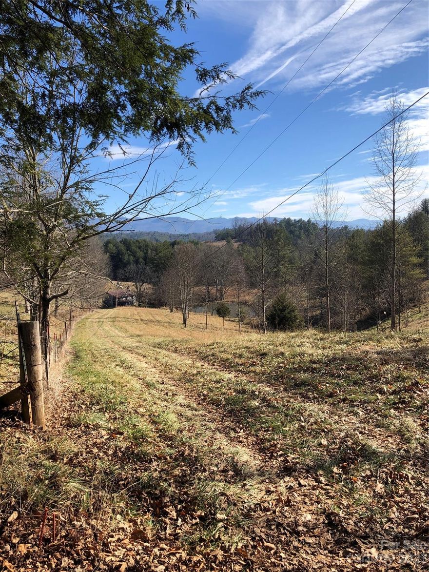 PRICE Reduction to $134,900!! A new Recorded Survey Feb 2024 - 8.60 acres with beautiful long-range "Blue Smoky Mountain" layered views!!  There are no restrictions with open use for your new family mountain home, camper or RV. Open use, no restrictions, NO HOA! The land is surrounded by other large private tracks and is very secluded with amazing views after some clearing.  An 18-foot-wide easement to the property is recorded in the deed. There are 3 buildable sites along the ridgeline. With some tree clearing you will have 180-270 degree beautiful long-range, multiple-layer mountain views. The creekfront is a low-flowing boundary line down the hill, along the property line. Centrally located 10 min to Marshall or Mars Hill, and 15 min to Weaverville NC. Asheville is 25 min away. The road is dirt and currently drivable. A gravel or paved road can be easily installed. Paved County Road access off of Silver Mill. Abundant wildlife. Beautiful Fall colors and long-range views.