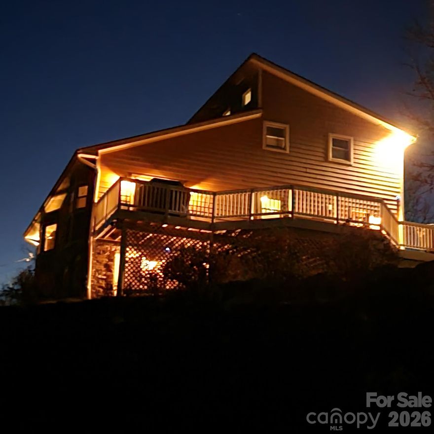 Nestled in a peaceful mountain setting, this stunning 4-bedroom, 4-bathroom home sits on 2.83 acres including an additional 0.18 parcel with no HOA or restrictions. Vaulted ceilings, a wood-burning fireplace, and walls of natural light create a warm, open living space where the surrounding mountains feel like part of the design. The spacious kitchen features ample storage and a charming bay window, while the main level also includes two bedrooms, a full bathroom, and a laundry room. Upstairs, a beautiful loft leads to the primary suite and an additional bedroom with two full bathrooms. The lower level offers flexible space ideal for a game room, media room, bar, or extra bedroom — complete with a full bathroom and generous closet space. A dedicated storage room off the garage is perfect for tools, hobbies, or a home gym. Outside, an expansive deck overlooks a 60+ acre pasture with long-range mountain views, complemented by two fire pits and a versatile yard with both level and gently sloping terrain — ideal for gardening, outdoor activities, and natural privacy. The property is loaded with premium features including hand-laid stonework, a whole-house Generac generator, advanced AI camera system, smart lighting, and a home security system. Location couldn't be better — just 5 minutes from Weaverville and 15 minutes from Asheville, with Reems Creek Falls only a scenic 15-minute hike away. The property is loaded with state-of-the-art technology and custom features, including hand laid stonework, a home security system, upgraded smart light switches, advanced AI camera system, and a whole-house Generac generator.