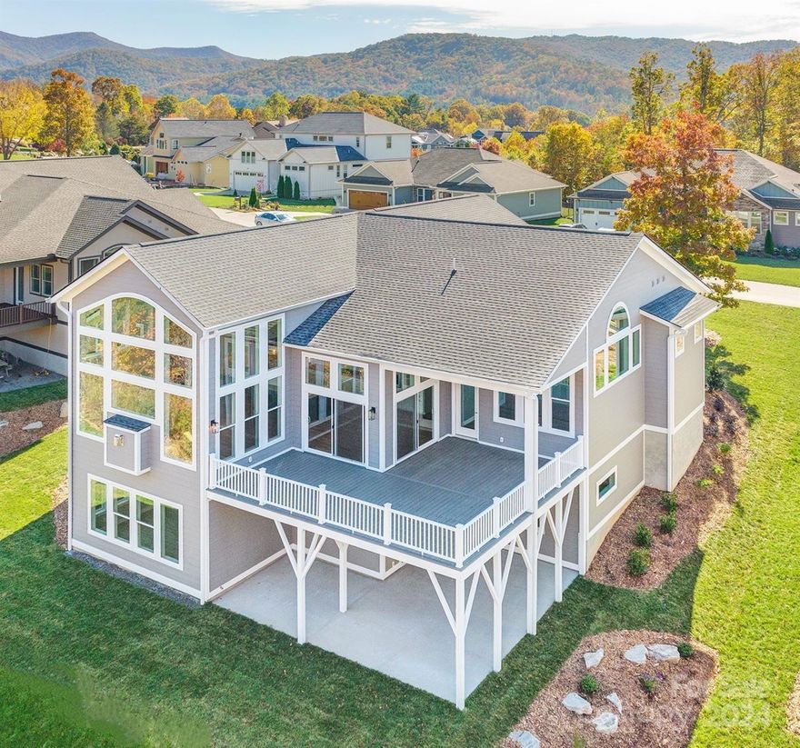 Magnificent 3 level designer home. Gaze upon forested mtn vistas & greenways through windows galore soaring to 20' vaulted ceilings. The great rm is surrounded by 16' walls of glass opening up to a private parklike setting. The dining area also surrounded by glass has its own niche with access to the expansive decks. A sprawling L shaped kitchen includes a 5x10 island that is a marvelous vantage point. The main floor adds 3 ensuite bedrooms, a vaulted primary suite with sky view transoms and direct deck access. Opportunities abound in the upper bonus room that peers over glass railings to great room below. A spacious lower level includes kitchenette, ensuite guest bedrm, flex rm, half bath and a family rm surrounded by glass and access to a large patio. Adjacent to golf club, a country mile to Weaverville, 10 min to Blue Ridge Pkwy & Asheville, Greenwood Park and neighboring Reems Creek Village is the ideal friendly mountain living community with natural gas, cable, city water & sewer.