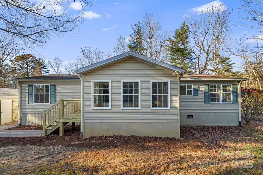 Discover comfort and convenience in this spacious 3-bedroom, 2-bath home with tall ceilings, a sunroom, and an open floor plan. Tucked away at the end of a private road, this move-in-ready home offers privacy and peaceful surroundings, just 12 minutes from vibrant downtown Asheville. Enjoy a large fenced frontyard and backyard—perfect for pets or gardening—and a generous detached workshop or garage. A rare find combining quiet country living with easy access to city amenities.