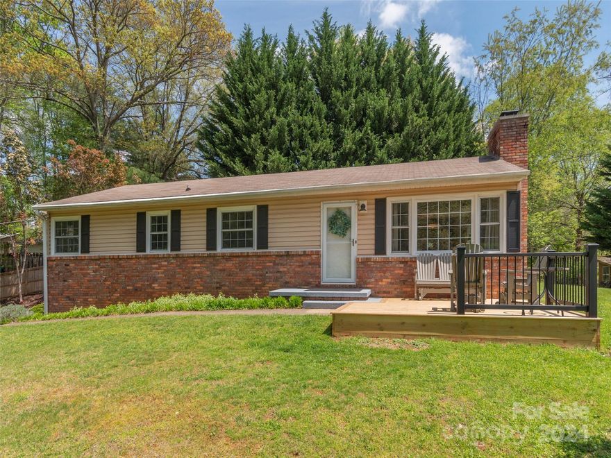 This mid-century home has been cleverly reconfigured & renovated to meet today's demanding tastes.  Light & airy with neutral decor, it offers comfortable living in a private setting that is just minutes from Downtown Asheville or the Blue Ridge Parkway. Refinished hardwood floors are throughout the house except for tile in the bathrooms.  The primary bath has radiant heat under the tile.  The kitchen is exceptional, being both a focal point for the house and very functional.  There is an oversized one-car garage and an equally sized unfinished basement area that has the potential to become a second garage. The yard has many shrubs and perennials, but there is also a large open area with full sun for play or a garden.  Across the street is a 1.3 acre wooded area that belongs to this neighborhood and increases the privacy for this property.  Being in the popular Haw Creek/Reynolds School District may be another reason this property might be a good choice for you.  See it today.