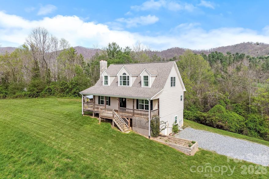 There is a quiet sense of ease to this charming Cape Cod-style home, set on 2.5 acres in a peaceful country setting where the landscape unfolds into wide-open green space and layered mountain ridgelines beyond. The views feel expansive yet grounding, creating a setting that invites you to slow down and take it all in.

A covered front porch extends the living experience outdoors, offering a natural place to begin and end each day with the surrounding scenery as your backdrop. Inside, the home is warm and inviting, with a living area centered around a classic brick fireplace and natural light that draws attention to the views.

The kitchen is thoughtfully arranged with ample cabinetry and workspace, including a breakfast bar, and opens to the dining area for a layout that feels both functional and comfortable. With 3 bedrooms and 2.5 baths, the home offers flexibility for everyday living and hosting guests.

A generously sized basement offers incredible potential, serving as a blank canvas for additional living space, whether envisioned as a guest retreat, home theater, or custom entertainment space.

The land itself is a defining feature, providing open, usable acreage for gardening, recreation, or simply taking in the quiet beauty of the setting. 

Quietly positioned yet within easy reach of Marshall and Asheville, the location offers a thoughtful balance of privacy and accessibility.