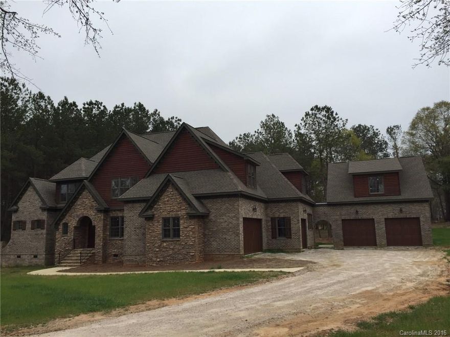 STUNNING home in equestrian community. Open floor plan w/ oversized kitchen w/ large bar w/ seating. Master bedroom on the main level with 5 additional bedrooms on upper level. All hardwood floors on main level and upper level w/ exception of carpet going in upper bedrooms. Large media room with fireplace and wet bar on upper level. Beautiful covered porch on the back of the home overlooking heavily wooded backyard. Many rooms of the home have great views of the community barn and pastures.