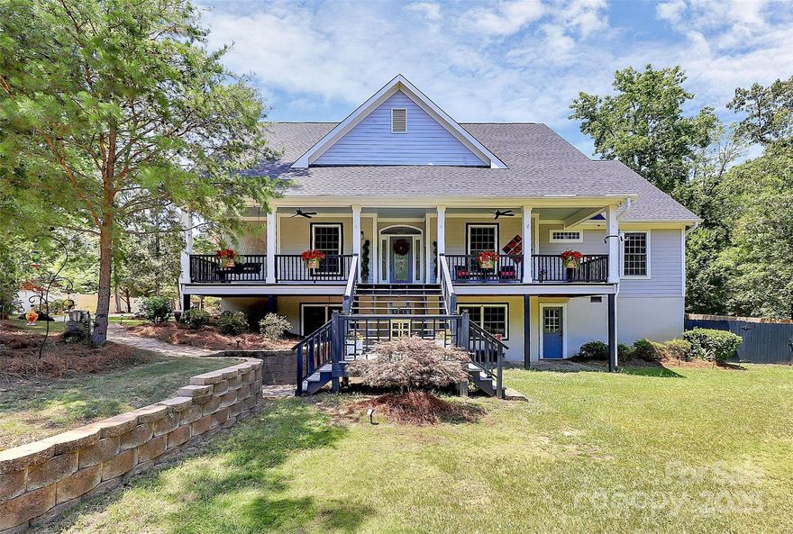 This kind of property rarely comes available—a true lifestyle w/space, privacy, & freedom to live how you want. All the rural feels but close to conveniences. This charming home sits on a serene 1 acre w/mature trees & a rocking-chair front porch that is straight out of Southern Living. Big windows & natural light to highlight the white kitchen, granite, herringbone backsplash, & stainless steel appliances. Mudroom is well appointed w/laundry, drop zone, sink, & full bath. Primary bedroom is spacious w/walk out access to deck where a hot tub soak under string lights is easy. 2 walk in closets, separate vanities, shower w/dual shower heads. Spacious secondary bedrooms share full hall bath & walk-out lower level adds 955 sq ft of finished rec space—perfect for entertaining, gym, office, or guest setup. Ready for chickens, goats, or whatever homestead dreams you envision? A small section of the rear yard is already enclosed. There is even a firepit and garden ready spot with irrigation!
