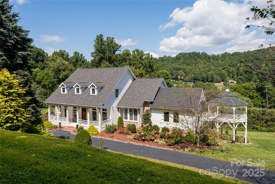 A rare mountain estate in Haywood County, this beautifully reimagined residence blends timeless elegance with modern comfort across 6.74 private acres. Sweeping mountain views unfold from every level, creating a serene retreat just three miles from Waynesville Golf & Country Club, boutique shopping and downtown Waynesville. The light-filled main level is designed for gracious living and entertaining, with updated family and dining spaces flowing into a formal living room. At the heart of the home, the chef’s kitchen features Bosch appliances, an induction cooktop, double ovens, and thoughtful details that elevate form and function. The primary suite is a peaceful sanctuary with a sitting area and spa-like bath. Upstairs, two bedrooms share a Jack-and-Jill bath, complemented by a spacious recreation room. The daylight walkout lower level offers a fully equipped second living space with kitchen, bedroom, bath and flexible rooms, ideal for guests or multigenerational living. A three-car garage and carriage house apartment add versatility. Outdoors, decks, gazebo and landscaped grounds invite year-round enjoyment. Private yet convenient, this exceptional estate offers refined mountain living at its finest.BRAND NEW ROOF.