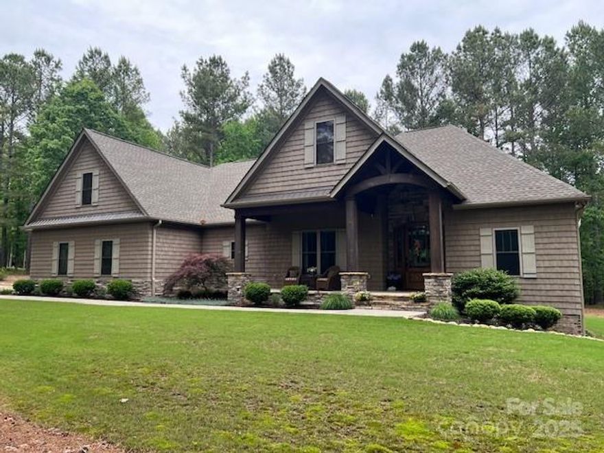 Experience lakefront living in the beautiful gated community of Anchors Landing.  Stroll from your home is your private boat dock, community pool, clubhouse, scenic ponds, pickleball courts, and miles of paved trails. Soaring solid timbers and a floor-to-ceiling stone fireplace create a warm and inviting great room, perfect for cozy evenings or entertaining. Handcrafted Knotty Alder cabinetry, granite countertops, upscale appliances, and a butler’s pantry elevate culinary experiences. A main pantry with custom shelving provides plentiful storage. Wake up in your primary suite to serene wooded views through a large picture window. The adjoining en-suite features an expansive open shower complemented by a 10x12 custom closet. The split bedroom layout offers abundant privacy.  The partially finished basement features a mini-split HVAC system for year-round comfort. A vaulted screened porch provides seasonal outdoor living. Lots within the community offer RV storage.