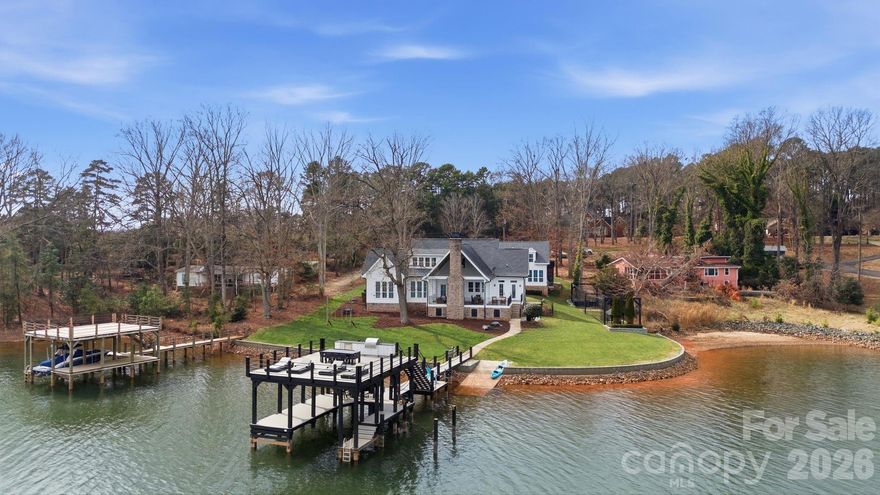 Welcome to "The Carolina House" on the shores of Lake Norman with serene views and deep water at your own private double decker dock awaiting your lake adventures. Charming front porch greets you before entering main level living drenched in natural light and captivating views. Make memories in the thoughtfully designed chefs kitchen with plenty of room for your guests to gather. An expansive lakeside back porch anchored by a cozy fireplace - the perfect setting and sunrise views for year round outdoor living and entertaining. Spacious upper level  with relaxing guest suite, flex room and a custom bunk-room. A private flex space above the carport offers exceptional versatility with plenty of storage space below. Perfectly positioned in a prime location, this is waterfront living at its finest.  NO HOA and only minutes to The Point Country Club with world class amenities and fine dining.