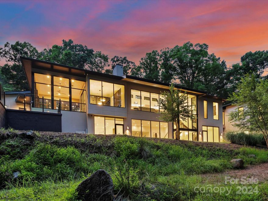 Located on a large wooded lot and designed by the award winning architects at Liquid Designs, the "Tree House" was designed to allow the home a lofty "among the tree line" feel. The primary suite is separated by a glass bridge and is accentuated by large expansive windows to provide tremendous views of the surrounding woodlands. Privately nestled on nearly 7 ac this stunning masterpiece boasts an open floorplan flanked by the elevator shaft converted into a rock climbing chamber. The kitchen features Wolf & Sub-Zero appliances, dual islands, exquisite walnut trim and is accented by a spacious, walk-in & climate controlled wine room. Following the floating staircase to the lower level, the epoxy floors really bounce all of the natural light. Zero entry shower on the ground floor, over-sized 2nd shower for utility. The glassed in sunroom can be converted to a screened-in porch. Scullery/mud room with custom cabinetry conveniently located off the kitchen. 3 car garage & a toy garage bay.