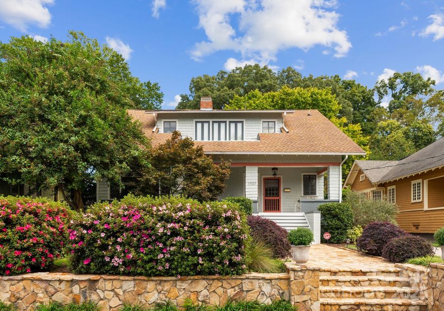 Timeless 1925 Bungalow in the Heart of Elizabeth. Step into history with this beautifully preserved 100-year-old bungalow, perfectly positioned within walking distance to the Gold Line, Novant Presbyterian, Independence Park and all of Elizabeth's fine shops and dining. A gracious oversized front porch welcomes you setting the tone for the home's iconic charm and livability. This 3 bedroom, 2.5 bath two story property features grand sun-filled rooms, from your foyer to your living room, dining room, sunroom and kitchen on main level. Gourmet kitchen features thoughtfully designed white cabinetry, GE Monogram appliances, dual beverage fridges, tile backsplash, pantry and desk niche. Convenient, large mud room with laundry and utility sink off your back entrance. Four iconic original fireplaces with decorative surrounds throughout the property. Elevated built ins showcase your front living room and quaint front sunroom. Upstairs features your oversized Primary Suite with luxury bath and walk in closet. Outdoors, enjoy your paver patio with fire pit area, an expansive deck built for entertaining, and a two-car detached hardy plank garage with unfinished space above built perfectly to finish out for an ADU if needed. This rare Elizabeth bungalow is not just a home, but a lifestyle-- classic, walkable and endlessly inviting.