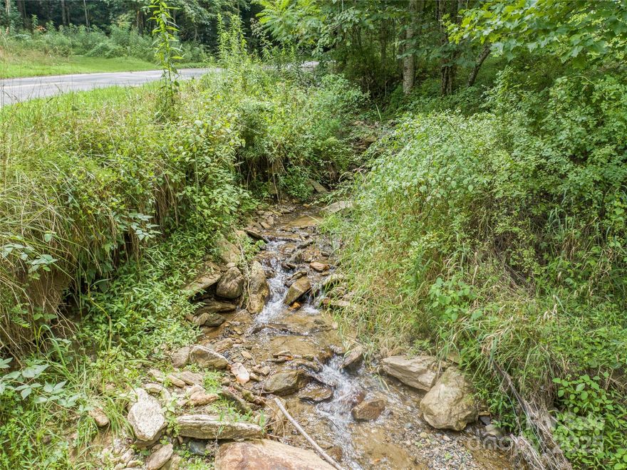 Find your perfect escape on this unrestricted 5-acre parcel, a true hidden gem nestled in the mountains of WNC. This is a property for those who dream of privacy and natural beauty. Enter your own private world by crossing a small stream & discover a wilderness that is truly your own. With a mountain view & peaceful creek frontage, the land is a haven for wildlife, with private trails carved by deer and other animals. It’s a place where you can watch the cattle graze on the nearby hillside. Whether you envision a rustic hunting cabin, a tranquil year-round residence, or a weekend getaway to clear your mind, this land can accommodate it all. Just 2 miles from a local trout stream, 20 minutes to Burnsville 45 minutes to Asheville. This property is perfect balance of seclusion and accessibility. Priced to sell and ready for your dreams to take shape!