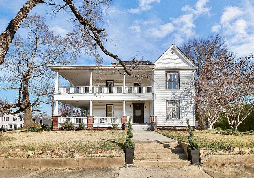 Become a member of historical downtown Lancaster! This home has been lovingly updated exuding all of the elegance and charm that living in downtown Lancaster offers. Enjoy scenic views of downtown from the upper floor porch and bedrooms or afternoon tea with the neighbors on your stunning wrap around porch. Entertain in one of the two living rooms featuring high ceilings and fireplaces original to the house. Enjoy cooking in a completely remodeled kitchen with double ovens, a glasstop stove and wine refrigerator. Formal dining room features custom built in cabinetry and fireplace. Beautiful original hardwood flooring through out the home. Primary bedroom with ensuite bathroom on main! Up the sweeping staircase, you'll find original gingerbread trim in the seating area, three additional bedrooms and two full bathrooms, with access to second story wrap-around porch. This unique property is a must see to appreciate its historical charm, conveniently located one block from Main Street.