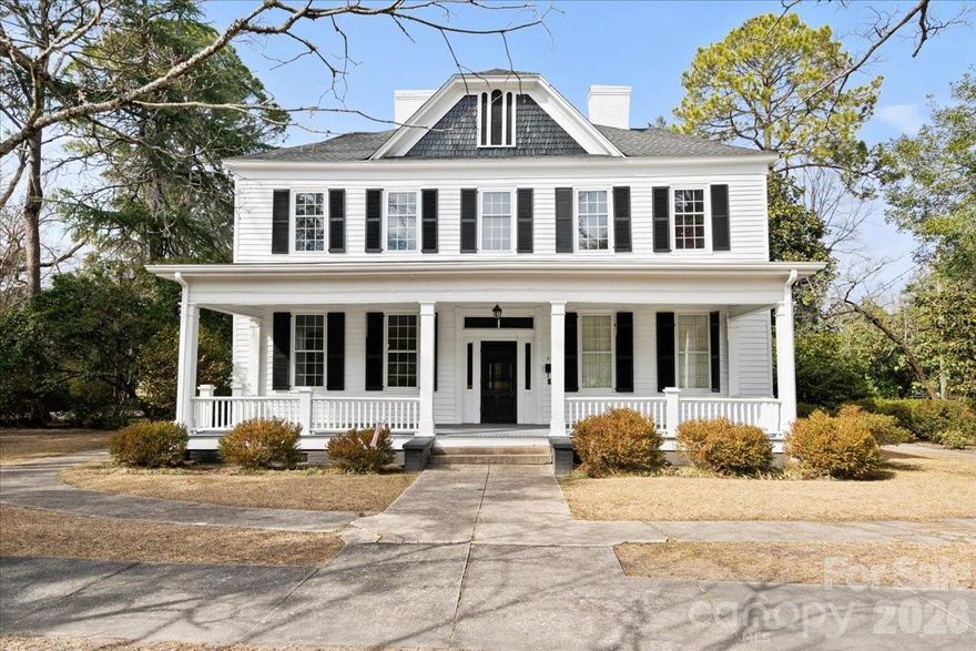 Introducing the historic McNair-Tillman House, one of the earliest homes built in Cheraw and notably the first residence on the entire third block of town. Rich in history and character, this remarkable property began as a classic “two-over-two” and has been thoughtfully expanded over the years to offer generous living space while preserving its original charm. With close to 4700 total sq ft, the main residence features 5 bedrooms, 3 full baths, and 2 half baths, with much of the original woodwork still intact—beautifully blending historic craftsmanship with modern updates. Renovated to its current layout in 2004, the back of the house is now connected with the original kitchen and opens up to a welcoming patio. This home has been well appointed, appreciated and maintained by its owners throughout its time. A standout feature is the attached 1-bedroom apartment, complete with a kitchen, full bath, living area, and private side porch. With its separate entrance and connection to the rear patio, this space is ideal for guests, extended family, or potential rental income. Set on nearly an acre, the property showcases mature landscaping and a deep backyard—perfect for outdoor living, entertaining, or simply enjoying one of the most private backyards in town. There is also a one car garage with additional storage that is also a more recent addition. This is rare opportunity to own a true piece of Cheraw’s history with space and flexibility in, perhaps, one of the best locations in town.