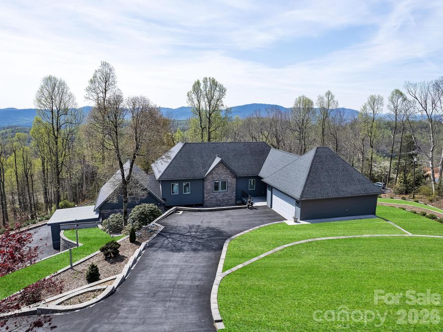 An extraordinary property with extraordinary views in desirable Laurel Park! Experience refined mountain living in this beautifully designed home featuring a truly distinctive floor plan. The main living areas are thoughtfully located on the lower level, creating a seamless blend of comfort, style, and everyday functionality. Energy-efficient hot water radiant heat warms the sleek concrete floors, while southern exposure fills the home with abundant natural light year-round.

At the center of the home, the open-concept kitchen impresses with a generous island, premium gas Thermador cooktop, and a striking metal tile subway backsplash. The primary suite offers a private retreat, highlighted by an expansive walk-through closet, a spa-like bath with a tiled step-in shower, a dedicated nook for a hot tub or freestanding tub, and a dual-sink vanity.

Additional living spaces include a guest bedroom with a full bath downstairs. Upstairs provides a connected workshop perfect for creative pursuits, and an upper-level bedroom with its own en-suite bath. A spacious fitness room and versatile bonus room provide flexibility for hobbies, work, or relaxation. Exceptional mountain views can be seen from almost every room of the house!

A detached outbuilding (built in 2019) with an overhead door adds even more potential, ideal for storage, vehicles, or studio use. Outside, take in sweeping long-range mountain views with both sunrise and sunset vistas, delivering stunning scenery throughout the day. The grounds offer over 2 acres of perennials and flowering trees. The perfect setting for gardening, bird watching and enjoying nature in Western NC. The exterior of the home was painted in September of 2025. 

This one-of-a-kind property combines luxury, efficiency, and thoughtful design to create an exceptional mountain retreat.
