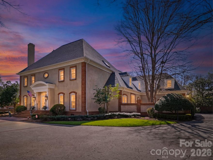 Timeless elegance with a modern-day twist defines this stately residence in the sought-after gated community of Seven Eagles. Situated on nearly an acre of private, gated grounds, this exceptional 6-bedroom, 7.5-bath estate welcomes you with a grand foyer with stunning marble flooring and a sweeping spiral staircase, flanked by a wood-paneled study with fireplace and a formal dining room, both showcasing beautiful trim work and craftsmanship rarely found in today’s new construction. The main level features a private guest suite with en-suite bath, as well as an expansive primary retreat with a dual-sided fireplace connecting the bedroom and spa-like bath, highlighted by dark green marble throughout and a sunken tub. A private staircase leads to an additional flex space ideal for a gym, office, or secluded lounge. The dramatic two-story living room is filled with natural light from wall-to-wall windows overlooking the backyard and seamlessly connects to the spacious kitchen, breakfast area, and inviting den with wet bar and fireplace—offering an open yet defined layout perfect for both entertaining and everyday living. Upstairs, you’ll find four additional bedrooms and a generous bonus room with wet bar, ideal for a secondary living or entertainment space. Outside is a one of a kind resort style oasis complete with a fountain, oversized pool, private whirlpool, separate pool bath and multiple gathering and lounging spaces.