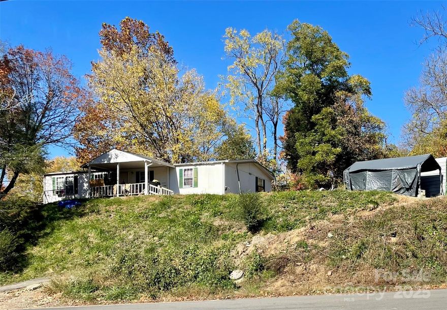 Home on .5 acres in Woodfin surrounded by newer residential development in close proximity to downtown Asheville and UNCA. Could be divided into 2 lots for one single family residence and one duplex per Woodfin Planning and Zoning. Dwelling needs work but location, views and development potential are amazing.