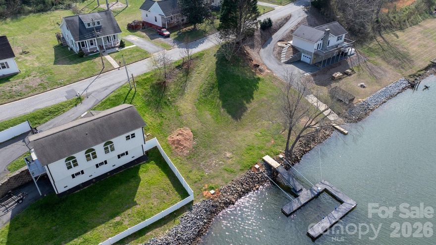 Nestled along the serene shores of Lake Hickory, this cleared and well-prepared waterfront lot offers an exceptional opportunity to create your own lake retreat. Designed for those who value time on the water, the property features a recently added pier with floating dock and boat lift (convertible for a standard boat or pontoon), already permitted and tagged. Whether you plan to build now or simply enjoy the property as a recreational lot, you’ll have immediate access to the water for boating, fishing, or soaking in the stunning lake views! Within this established lakefront neighborhood, some shoreline lots include acreage that extends into the lake itself. For this property, approximately 0.6369 acre is lake-covered, with about 0.22 acres of usable land. The sellers have already taken proactive steps by identifying the most suitable buildable area, taking the flood zone fully into account, and locating a home plan designed to fit comfortably within that space, offering a valuable head start toward future construction. With electric, water, and sewer available, this property is ready to support your vision. The thoughtful layout maximizes usable space while highlighting what makes this location special: direct water access, peaceful surroundings, and the flexibility to enjoy the property now while planning for the future. Whether you’re dreaming of a weekend getaway or a full-time waterfront escape, this property delivers a rare combination of preparation, flexibility, and prime Lake Hickory access.