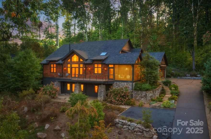 Stunning 2018-built custom home with year-round mountain views just two miles from downtown Asheville in sought-after Beaucatcher Heights of Kenilworth. This 4BR/4.5BA offers ideal one-level living with the primary suite, laundry, and garage on the main floor. Its modern, open floor plan includes a living room with massive windows, a stone and natural gas fireplace, and a custom stairwell and built-ins. The chef’s kitchen dazzles with Alder cabinetry, leathered granite, a walk-in pantry, an oversized eat-in island, and screened porch access for outdoor dining. The spacious Cumaru deck, private stone back patio, and mature landscaping create a serene retreat. The primary suite offers a spa-inspired ensuite bath and a large custom closet. Upstairs includes two ensuite bedrooms; basement adds a guest suite, living area, and abundant storage/workshop space. An attached two-car garage and office space all complete this thoughtfully designed home. See video, brochure, and floor plan for more information.