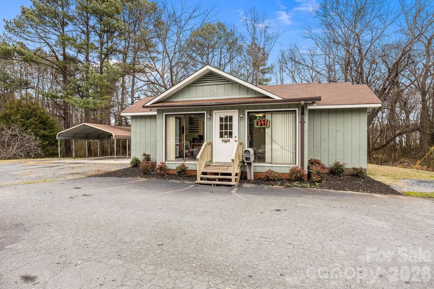 Excellent investment or owner-user opportunity on highly visible US Hwy 52 N in Albemarle with over 13,000 vehicles per day. This commercial property is currently leased to a car rental tenant, offering immediate income potential. The building features 4 private offices, a front waiting/reception area, kitchenette, and 2 restrooms, providing a functional layout for a variety of commercial uses. HVAC replaced in 2023, roof replaced between 2015–2020, and exterior freshly painted in 2025. Situated on 5.79 acres with a paved parking lot. Portions of the acreage lie in a flood zone; however, the building itself is not located in the flood zone. Additional improvements include a 2-car metal carport.  Prime highway exposure, strong traffic count, and recent updates make this a standout commercial property.