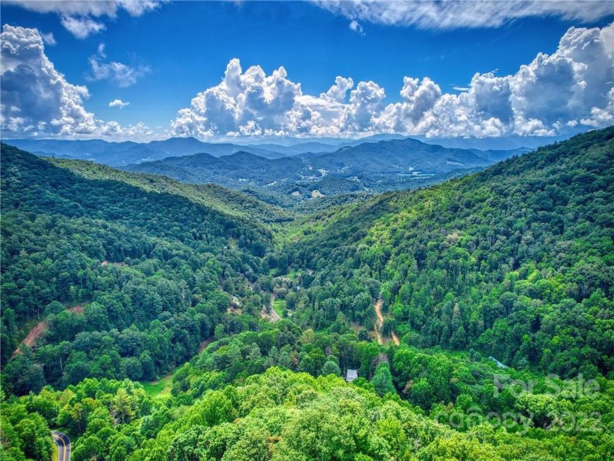 Beautiful High elevation wooded land on Cove creek with long range views. Can be subdivided into 3 parcels. House pads and driveways roughed in for 3 home sites. Unrestricted and easy paved access. Minutes to Waynesville, Asheville and the National park