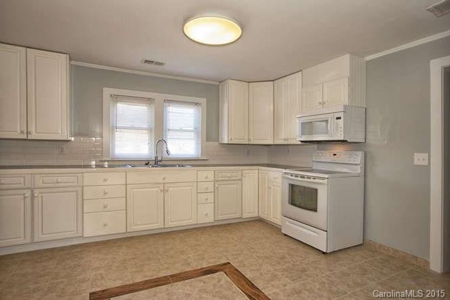 Newly remodeled home features gorgeous hardwood and tile throughout. You'll love the kitchen with plentiful cabinets, new refrigerator and new built-in microwave. One bedroom has a private bath, 1 additional bath with large walk-in shower.  Laundry/mud room at back entrance.  Central heat and air.  Quiet street.