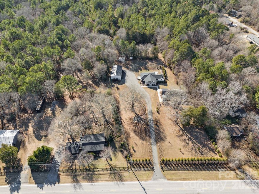 Private acreage, thoughtful infrastructure, and room to grow — 5412 Echo Valley offers a rare opportunity to own approximately 2 wooded acres with flexibility for multi-generational living or future expansion. Conveniently located just 35 minutes to Fort Mill and Scout Motors, approximately one hour to Charlotte or Columbia, and minutes from Great Falls’ outdoor recreation, this property delivers both seclusion and accessibility. The main residence features 3 bedrooms and 3 full baths, hardwood flooring, and bright, inviting living spaces ideal for everyday comfort or entertaining. A covered front porch overlooks the land, creating the perfect setting for quiet mornings and relaxed evenings. A detached guest house includes a full kitchen, spacious living area, outdoor kitchen, and a bathroom that could easily be upgraded to a full bath with shower — ideal for extended family, guests, remote work, or private retreat space. Additional highlights include a four-car, climate-controlled garage/workshop with commercial refrigeration, and potting shed— offering exceptional versatility for storage, hobbies, recreation, or animals. This property is part of a larger connected offering, with additional contiguous parcels available along the road and behind the property — presenting a rare opportunity to create a true family compound or legacy estate.