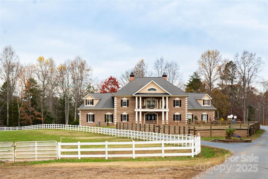 Welcome to an exceptional equestrian estate offering 58+ acres of privacy, luxury, and versatility in a highly sought-after Davidson location with Mooresville schools. Designed as a premier horse property yet equally suited for a family compound, event venue, or private sanctuary, this estate combines state-of-the-art amenities with timeless elegance.

A gated entrance and fence-lined paved drive set the tone as you approach the property, passing world-class equestrian facilities along the way. The centerpiece is a professional 10-stall barn, complemented by two riding arenas—a large indoor arena and an outdoor arena—along with an equipment building and fenced pastures. A charming 2-bedroom, 2-bath guest house provides additional accommodations for family, caretakers, or visitors.

The main residence makes a striking first impression with its circular driveway, grand double-door entry, and soaring two-story foyer. Expansive walls of windows frame picturesque views of the property, seamlessly blending the outdoors with the open-concept living spaces. The great room, dining area, and chef’s kitchen flow together effortlessly, perfect for both everyday living and entertaining on a grand scale.

Thoughtfully designed, the home’s dual-wing layout creates a private courtyard oasis with a sparkling pool at its heart. The main-level primary suite serves as a retreat of its own, featuring a large bedroom, two walk-in closets, a spa-inspired bath with dual granite vanities, whirlpool tub, custom built-ins, and a versatile flex room.

Upstairs, the entertainment options continue with a true home theater, a game room with wet bar, and a guest suite with balcony overlooking the rolling acreage and farm amenities.

Beyond the home, outdoor living and recreation are abundant. Meandering trails invite exploration on horseback or foot, while shuffleboard and horseshoes offer classic pastimes. Every detail of this estate has been designed to create an environment that is as functional as it is beautiful.

Originally built by a NASCAR driver, the property carries a legacy of performance and prestige. Whether envisioned as a working equestrian farm, a family retreat, or a venue for hosting unforgettable events, this property offers endless opportunities—all within minutes of Davidson and Lake Norman, with the convenience of top-rated Mooresville schools.