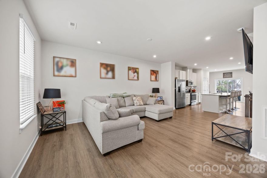Welcome to this beautifully designed 3-story townhome in the sought-after Towns at Mallard Mills community, built in 2023 and perfectly crafted for modern living. This move-in-ready home features 3 spacious bedrooms plus a versatile lower-level flex room ideal as a 4th bedroom, home office, media room, or fitness space. The open-concept main level is ideal for entertaining and everyday comfort, showcasing a stylish kitchen with granite countertops, a large center island, abundant cabinetry, and sleek finishes throughout. Durable luxury vinyl plank flooring enhances the main living areas, offering both elegance and easy maintenance. Step outside from the kitchen onto the private deck overlooking peaceful wooded views—perfect for morning coffee or relaxing evenings. Upstairs, the luxurious primary suite provides a private retreat complete with a soaking tub, walk-in shower, double vanity, and generous walk-in closet. Two additional bedrooms share a full bath, while the conveniently located upper-level laundry closet adds everyday convenience. The lower level offers endless possibilities with a spacious bonus/flex room and direct access to a private patio, creating additional indoor-outdoor living space. A 1-car garage provides extra storage and convenience. Ideally located near Hwy 485, shopping, dining, and entertainment, this modern townhome offers the perfect blend of comfort, style, and convenience in a rapidly growing Charlotte area community. Don’t miss your chance to own this exceptional home in The Towns at Mallard Mills!