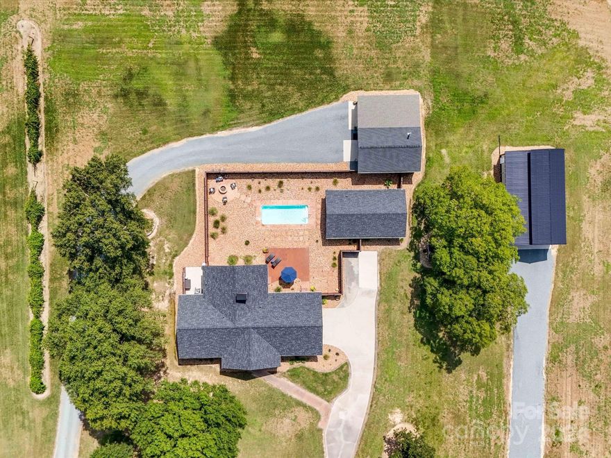 Escape to your own private oasis with this sprawling brick ranch, offering over 2400 sqft situated on 2.5 acres of lush, beautifully landscaped grounds. Home features open layout with 3 bedrooms & 2 full baths. The heart of this home is a stunning sunroom that overlooks a sparkling in-ground saltwater pool—perfect for relaxing and entertaining. The pool house, complete with a roll-up bar door, kitchenette, and plenty of space, makes hosting gatherings a breeze. Whether you’re enjoying a quiet evening or entertaining guests, this setup is sure to impress. For the hobbyist, a detached garage w/woodstove provides ample space for projects and storage, while an additional fully insulated metal building offers RV parking and even more room for your needs. Lots of updates and meticulously maintained inside and out!  Located conveniently to the Monroe Bypass & Highway 74, you’ll enjoy the perfect blend of country living with easy access to all that the surrounding area has to offer.