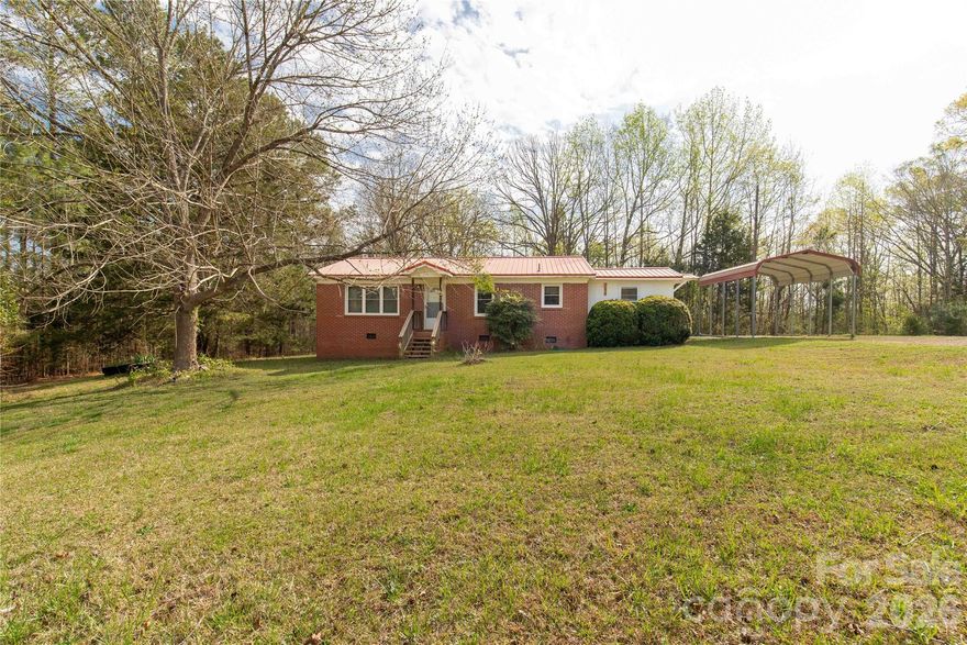 Brick ranch located in the highly desirable Buford School District offering a rare blend of usable acreage, functional improvements, and relaxed rural living on 2.8 acres. This 3 bedroom, 1 bath home features a comfortable and efficient layout with a kitchen equipped with a stove, refrigerator, breakfast bar, dining area, and pantry. Warm knotty pine paneling flows through the kitchen and into the living room, adding character, texture, and a cozy cabin-like feel that sets this home apart from typical ranch-style properties.
A durable metal roof enhances durability and peace of mind, while the brick workshop expands the possibilities for storage, hobbies, tools, or creative projects.  Outside is where this property truly shines. The 2.8 acres offer room to spread out, garden, host gatherings, enjoy outdoor living, or explore small homestead-style use. Whether you envision space for animals, a firepit hangout area, or simply extra elbow room between you and neighbors, this property delivers that increasingly hard-to-find sense of privacy and flexibility. Two camper hookups are also in place for added utility.

This is an excellent opportunity for a first-time home buyer or anyone seeking affordability paired with land ownership in Buford School District. A property like this offers more than just a home—it offers breathing room, usability, and the chance to shape the land & home into your own vision, all while staying conveniently located to everyday essentials.