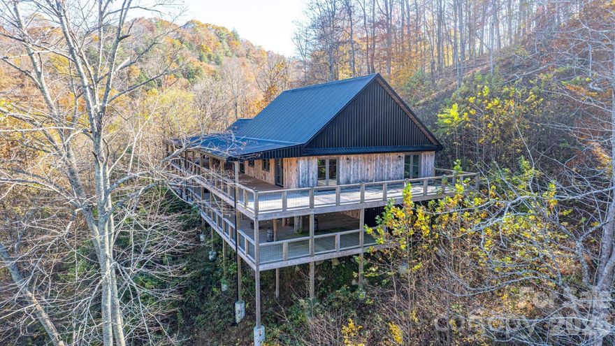 The Appalachian Lodge at Rivers Bend is a combination of single family luxury and event space opportunities.  It can be used in a variety of ways.  Located just a few minutes from Marshall on a bluff overlooking the French Broad River and mountains beyond, this is an idyllic hideaway for anyone seeking privacy yet convenience for a large family, friends or homestead.  The River Lodge is designed for events with an enormous two level deck of nearly 5,000 square feet for entertaining and a 2,100+ s.f. meeting hall with high ceiling ideal for big events.  To one side is a residential wing with large Primary Bridal Suite and luxurious bath along with kitchen featuring commercial touches along with lobby/sitting area and half bath.  Downstairs are two bedrooms, den and bath with two private water closets and walk in tile shower.  The lodge sits 200' above the French Broad River with outstanding views to the river.  The acreage features well defined trails and logging roads leading to numerous spots with excellent topography for additional structures.  This property could not be reproduced for anything close to the asking price.  The adjoining parcel of 7.2 acres with 4BR "Mountain House" is available as well (see MLS 4317608 SFR for BOTH parcels combined or MLS 4342825 SFR for only the 7.2 acres and 4BR Mountain House).  Only qualified buyers please.  Must provide proof of funds prior to showing and at least 48 hours notice.