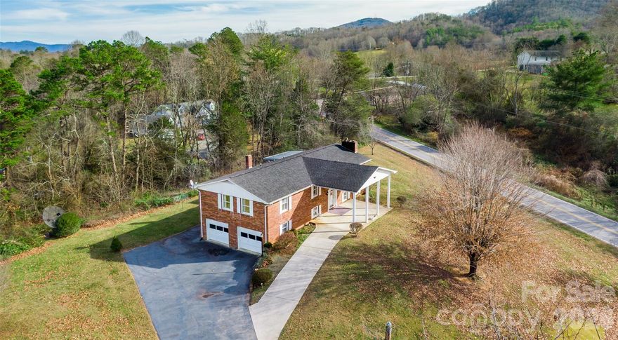 This one-owner brick home offers solid construction, mountain views, and a layout that can be reimagined to fit your vision. With many original features intact, the property offers a great opportunity to reimagine and refresh the home with modern updates.
The main level includes a spacious living room with a wood-burning fireplace, a large kitchen with an island, a dining room, and three bedrooms, including the primary suite with deck access. The lower level adds valuable square footage with a second fireplace, full bath, bonus room used as a fourth bedroom, laundry, and a large family room with new flooring and walk-out access.
Outdoor living is easy with a wide deck, covered front patio, and a usable yard. A heated garage workshop, ample parking, and no city taxes add to the appeal. 
Bring your vision and your contractor—this home is ready for its next chapter.